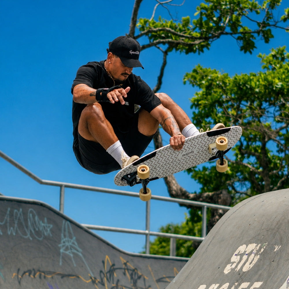 SpiceSkate rider jumping with surfskate board in skatepark
