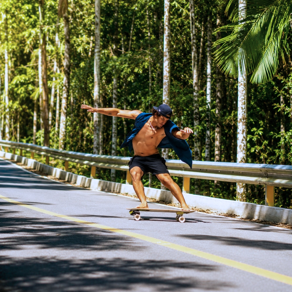 SpiceSkate rider making a deep surf-style turn on a city road